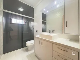 Banheiro moderno com bancada e box de vidro em Lajeado.
