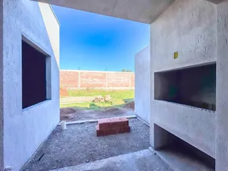 Vista de um pátio externo delimitado por paredes brancas de uma propriedade.