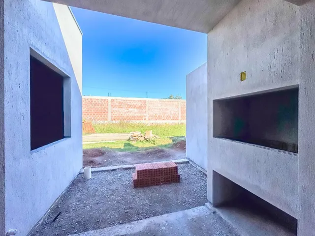 Vista de um pátio externo delimitado por paredes brancas de uma propriedade.