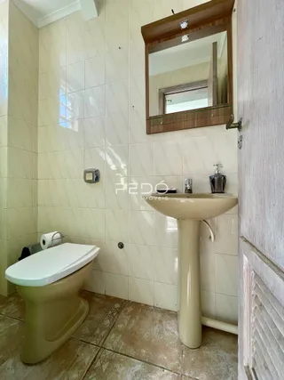 Foto de um banheiro interno com azulejos brancos e piso de cerâmica.