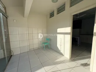 Interior de uma sala com piso de cerâmica e paredes brancas.