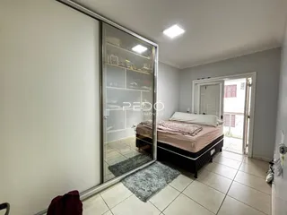 Quarto com cama e divisória de vidro em um imóvel no Brasil.
