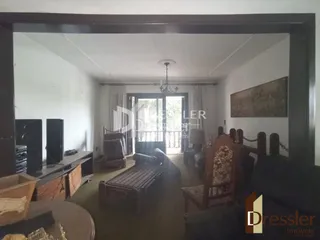 Interior de uma sala com móveis de madeira e uma pintura na parede.