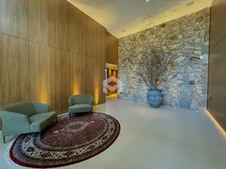 Sala de estar com paredes de madeira e destaque em pedra.