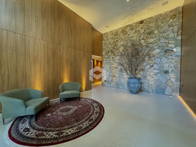 Sala de estar com paredes de madeira e destaque em pedra.
