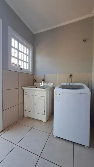Vista de um cômodo interno com piso de cerâmica e armário branco.