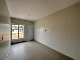 Ambiente interno de uma sala com piso de cerâmica e janela.