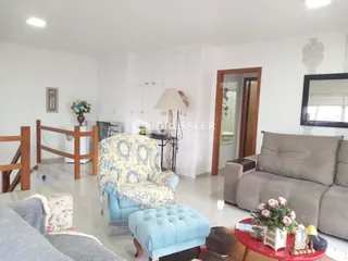 Sala de estar com sofá e poltrona em um ambiente claro.