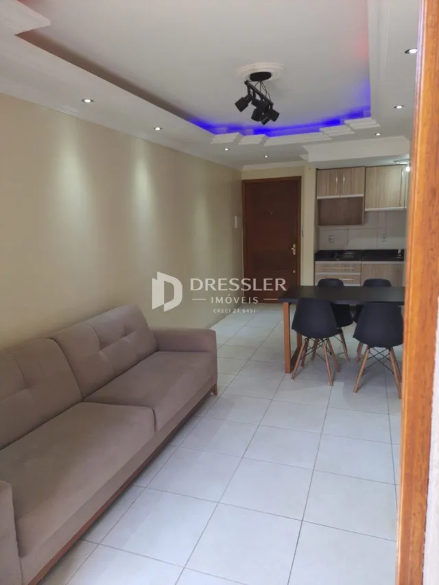 Sala de estar com sofá e piso cerâmico claro.
