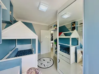 Quarto com camas de solteiro e armários em um ambiente com paredes azuis.