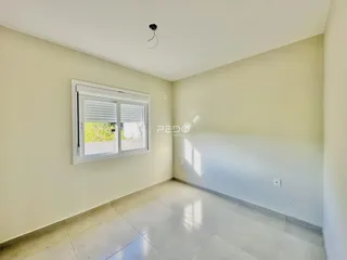 Foto de um cômodo interno com paredes claras e piso de cerâmica.