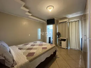 Foto de um quarto com cama e piso de cerâmica em uma residência.