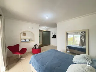 Quarto com cama azul e espelho na parede de uma residência.
