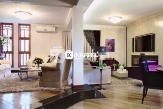 Sala de estar com sofá e televisão em ambiente interno.