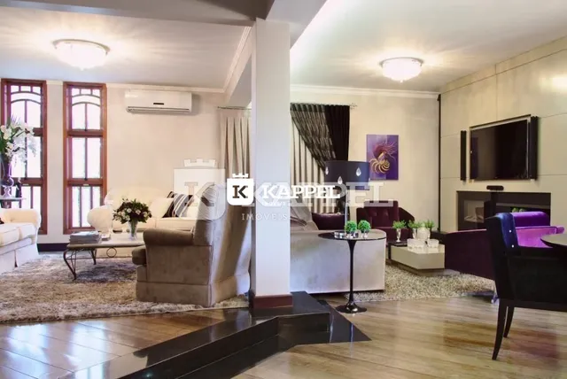 Sala de estar com sofá e televisão em ambiente interno.