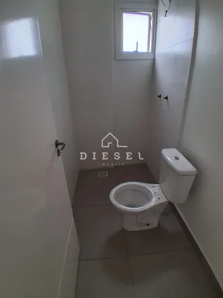 Foto de um banheiro interno com piso cerâmico e vaso sanitário branco.
