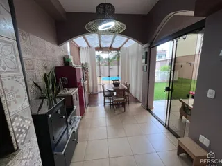 Sala de jantar com vista para piscina e jardim.