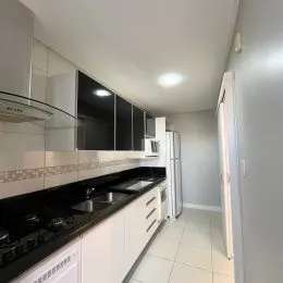 Foto de uma cozinha com armários escuros e bancadas pretas.