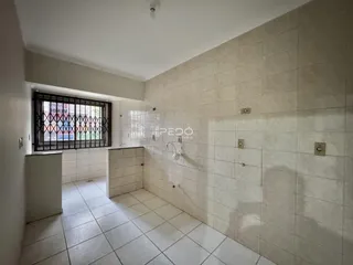 Ambiente interno de um banheiro com piso e paredes revestidos em cerâmica branca.