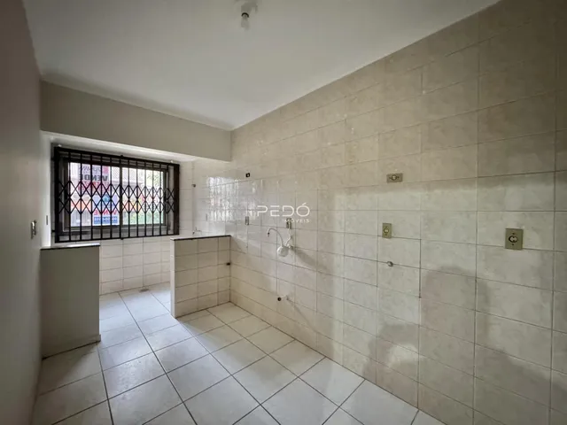 Ambiente interno de um banheiro com piso e paredes revestidos em cerâmica branca.