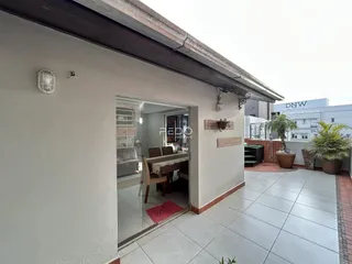 Fachada externa de uma residência com piso de cerâmica e área externa.