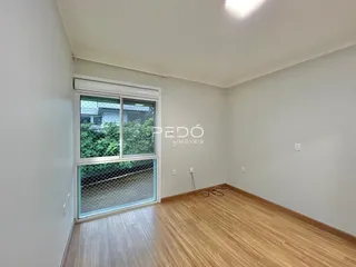Ambiente interno com piso de madeira e janela.