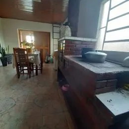 Sala de estar com piso de madeira e parede de tijolos visível.