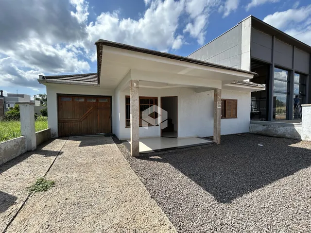 Fachada de uma casa em Lajeado, Brasil com garagem e área externa de cascalho.