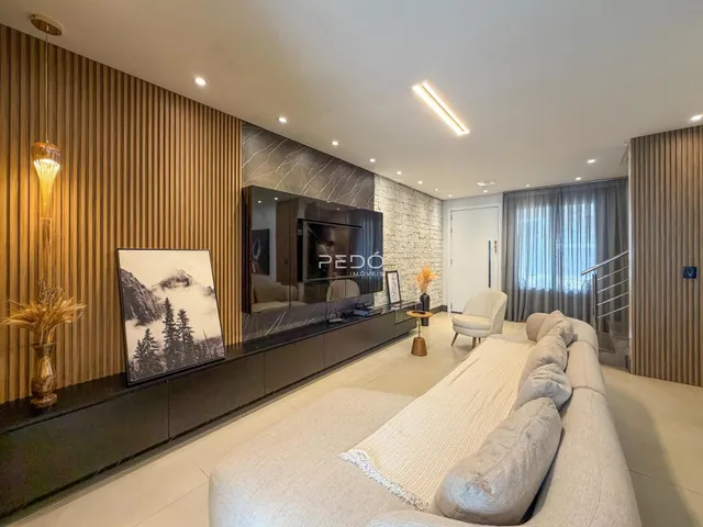 Sala de estar moderna com sofá e decoração de parede em um imóvel no Brasil.