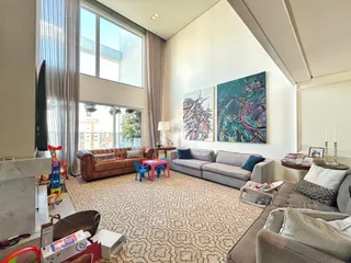 Sala de estar com sofá e grandes janelas em um imóvel no Brasil.