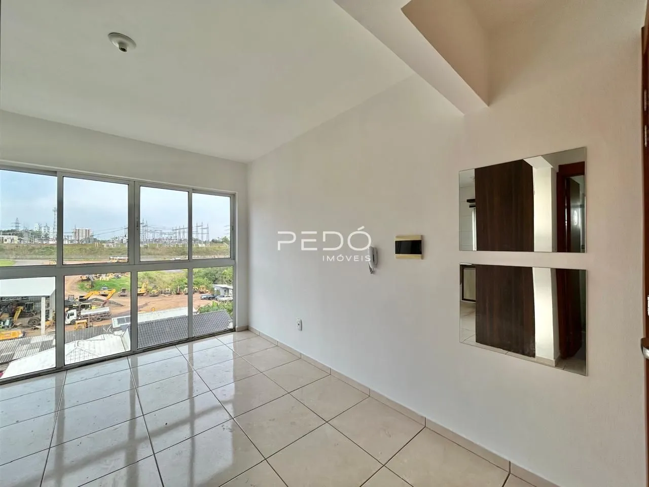 Sala de estar com grandes janelas que oferecem uma vista para a área externa.