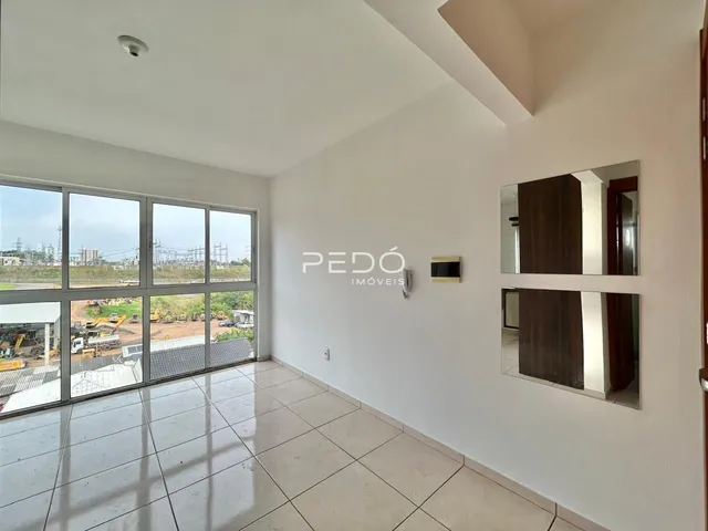 Sala de estar com grandes janelas que oferecem uma vista para a área externa.