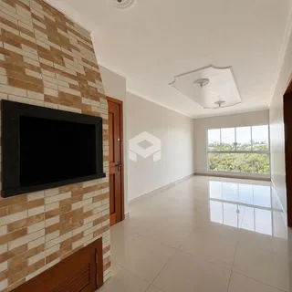 Interior de uma sala com parede de tijolos e piso claro.
