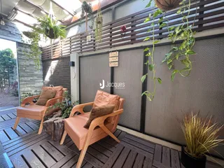 Área externa com deck de madeira e móveis de exterior.
