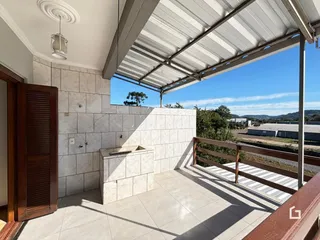 Vista da sala de estar com acesso a uma varanda coberta.