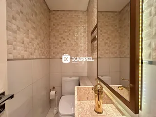 Banheiro com revestimento de azulejos e bancada de mármore.