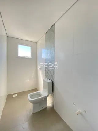 Foto de um banheiro interno com piso de cerâmica e paredes brancas.