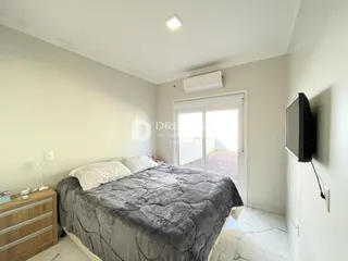 Quarto com cama e porta de vidro abrindo para o exterior.