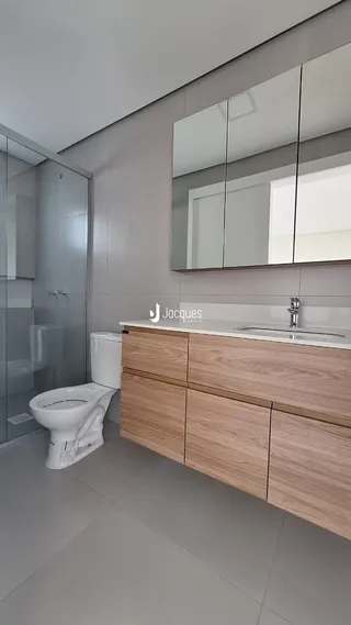 Foto de um banheiro moderno com box de vidro e bancada de madeira.