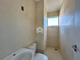 Foto de um banheiro interno com piso cerâmico e paredes claras.
