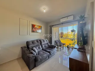 Sala de estar com sofá e vista para o exterior em Lajeado.