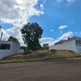 Foto da fachada de uma propriedade com área externa de terra e vegetação.