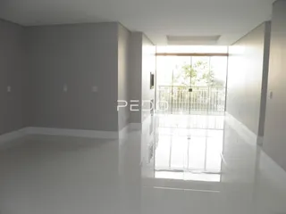 Interior de uma sala com piso reflexivo e paredes cinzas