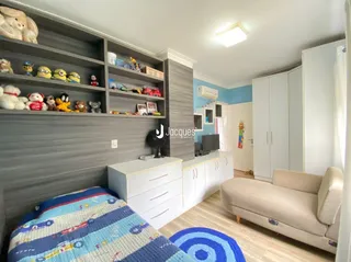 Sala de estar com estantes e sofá branco.