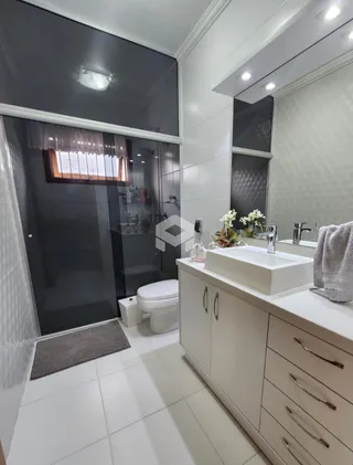 Foto de um banheiro com revestimento branco e bancada moderna.