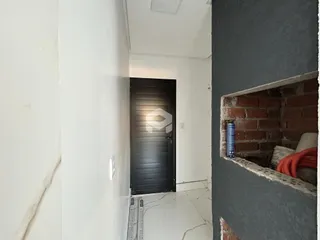 Vista de um corredor interno com parede de tijolo exposto.