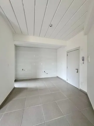 Foto de um cômodo interno com teto inclinado e piso de cerâmica.