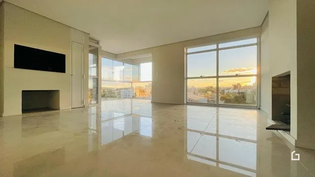 Interior de uma sala ampla e iluminada com piso de cerâmica polida.