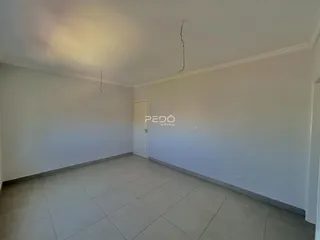 Ambiente interno de uma sala com piso de cerâmica clara e paredes brancas.
