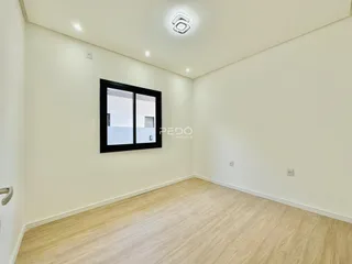 Ambiente interno de uma sala com piso de madeira clara e janela.